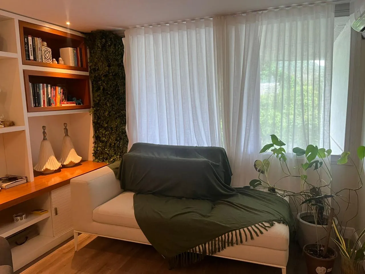 Sala de atendimento com sofá, livros e luz natural